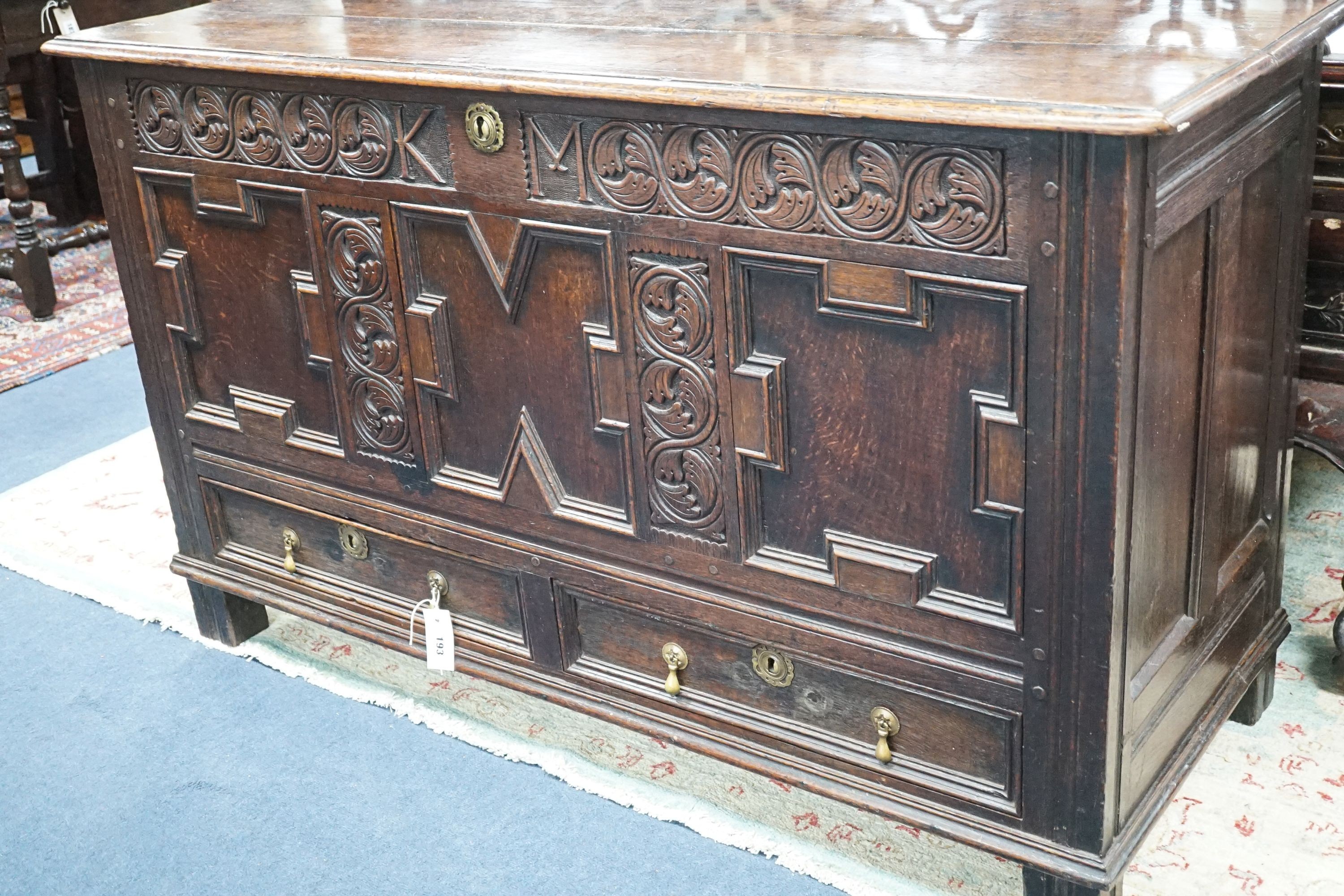 A William and Mary carved oak mule chest with K M initialled frieze and triple panelled front, length 132cm, depth 51cm, height 78cm
